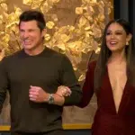 **Alt text:** *Love Is Blind Season 9 hosts walking arm in arm and smiling during a scene from the show.*